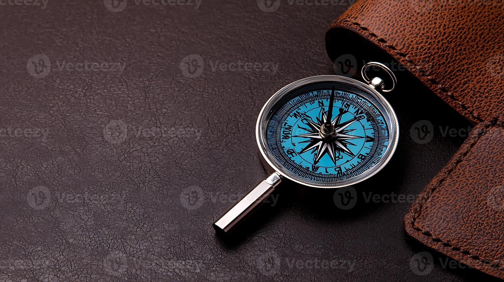 Close-up of a compass on a brown leather surface, symbolizing navigation and exploration themes photo