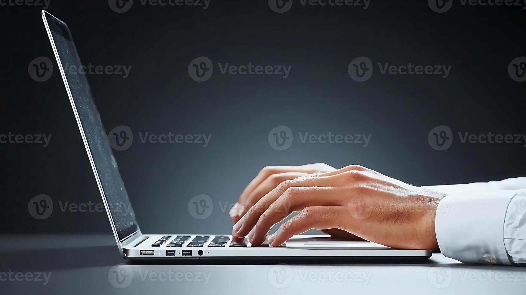 Close-up of a person's hands typing on a laptop in a dimly lit environment, focusing on productivity photo