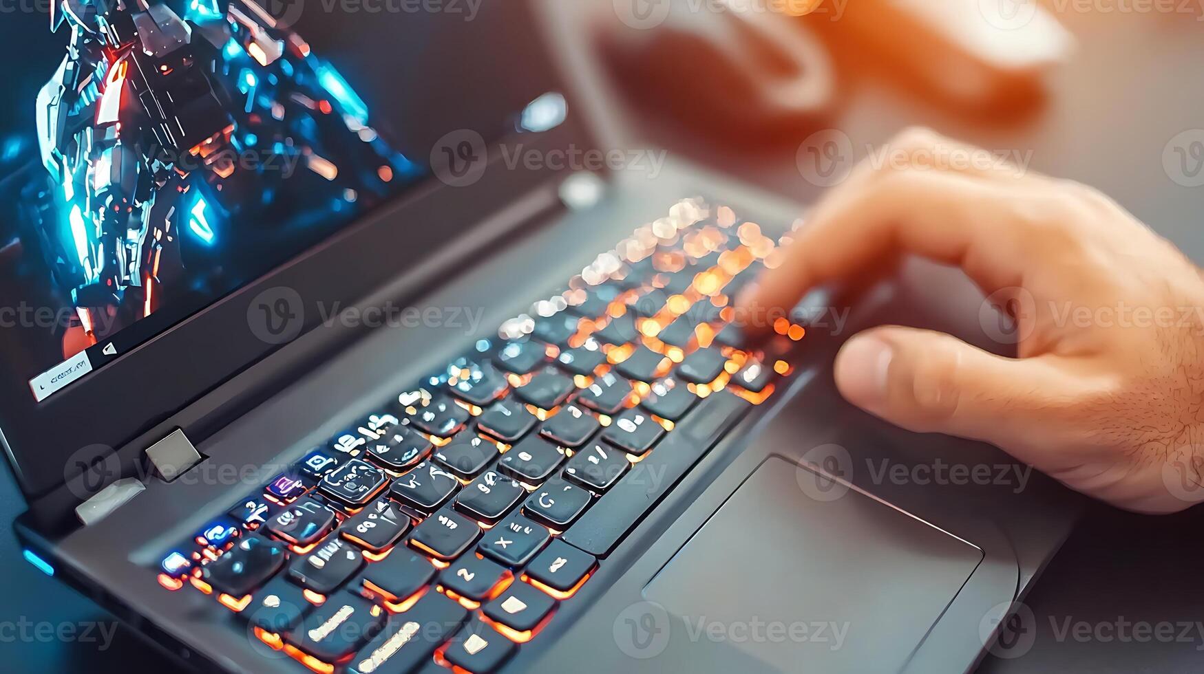 Close-up of a person using a laptop with a vibrant screen displaying futuristic graphics photo