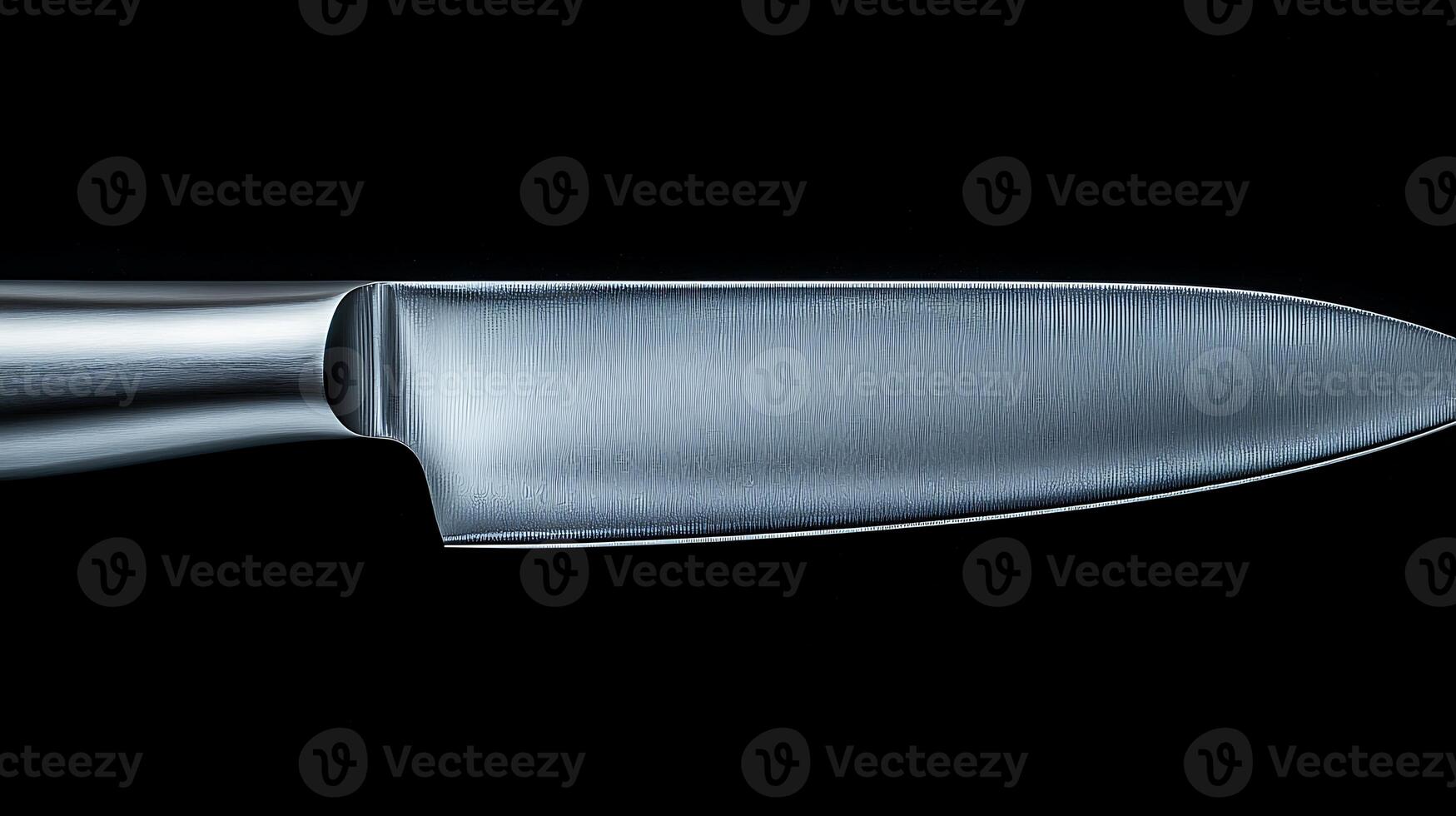 Close-up of a polished kitchen knife against a black background, showcasing its sleek design and sharp edge photo