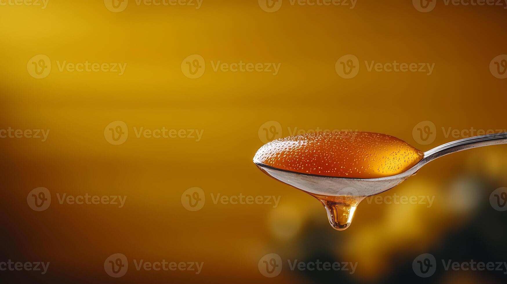 Close-up of a spoonful of honey glistening under warm golden light with blurred background photo