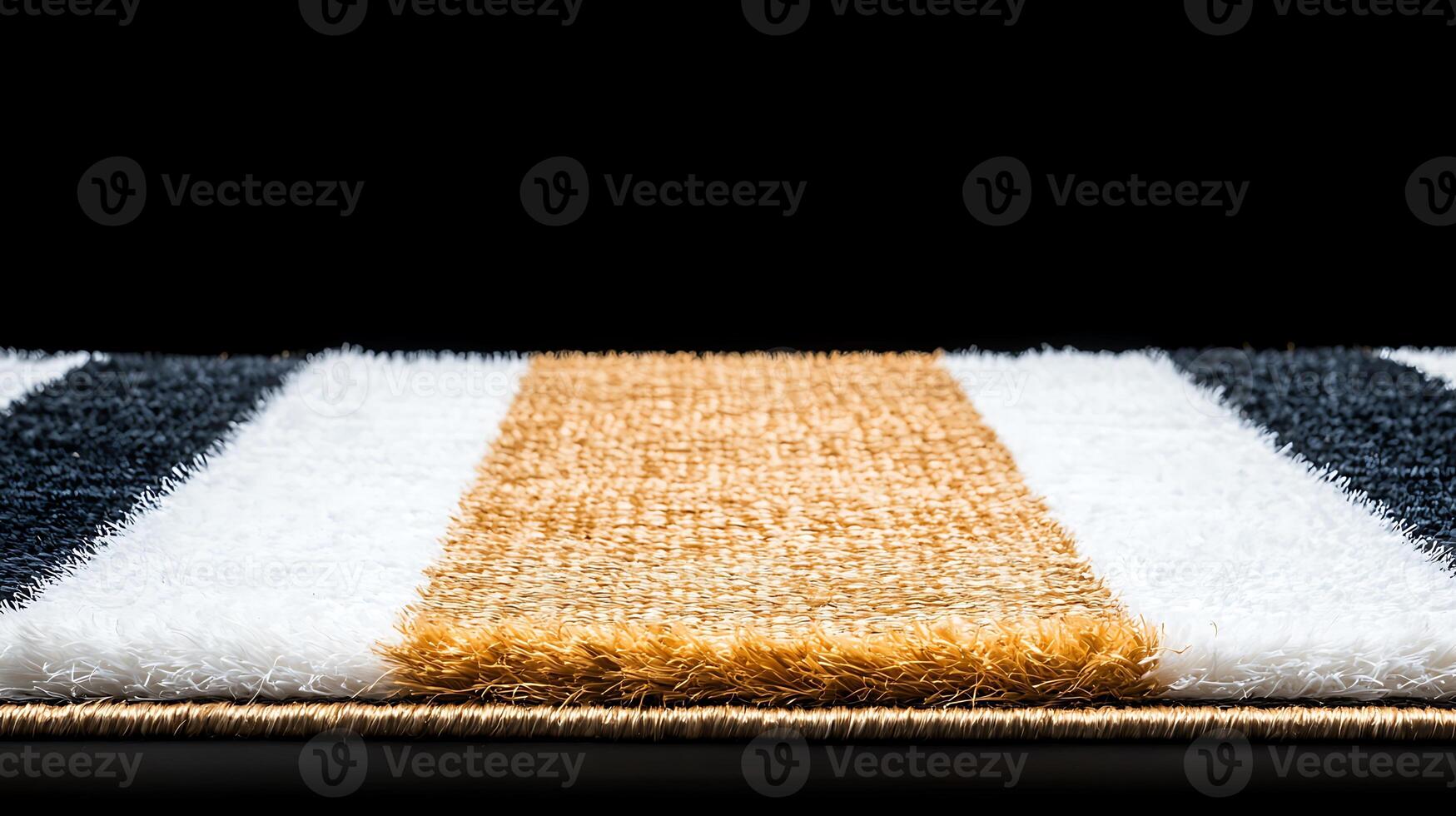 Close-up of a textured rug with striped patterns in black, white, and gold on a dark background photo