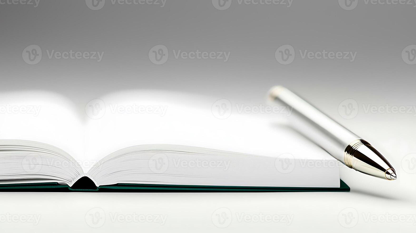 Close-up of an open book with a silver pen resting beside it on a smooth, gradient background photo