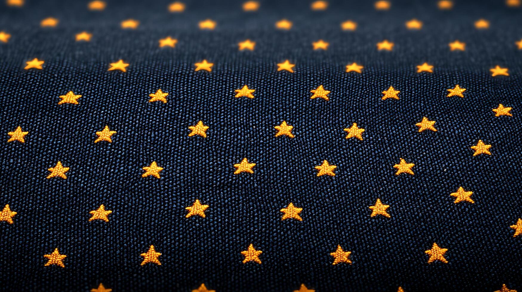 Close-up of navy fabric with scattered orange star patterns, ideal for textile design projects photo
