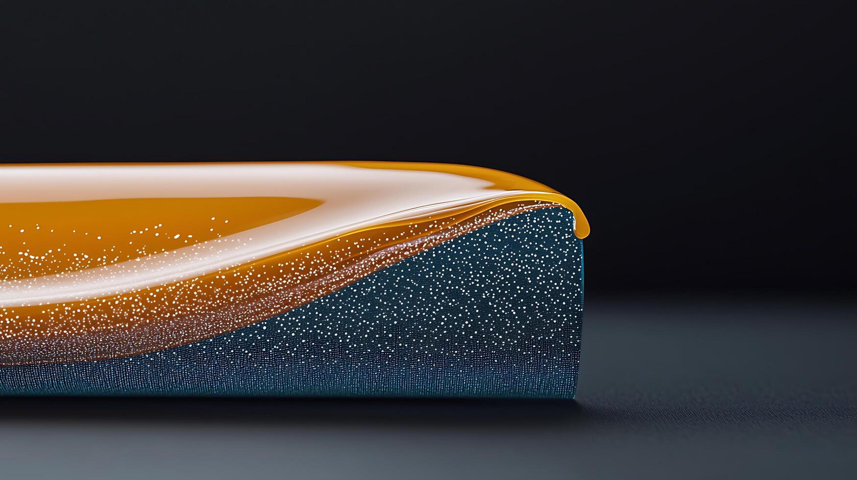 Close-up view of a glossy orange and blue fluid wave on a dark background, creating a vibrant contrast photo