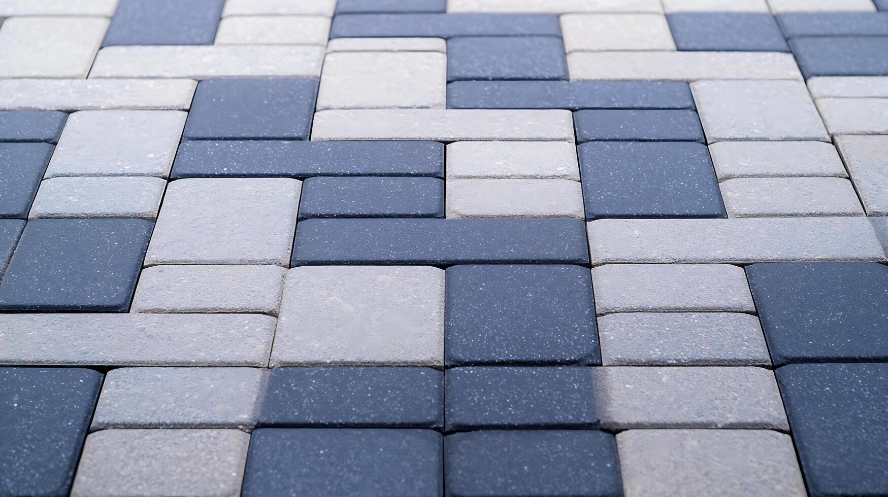 Close-up view of a patterned stone pavement showcasing a mix of dark and light tiles photo
