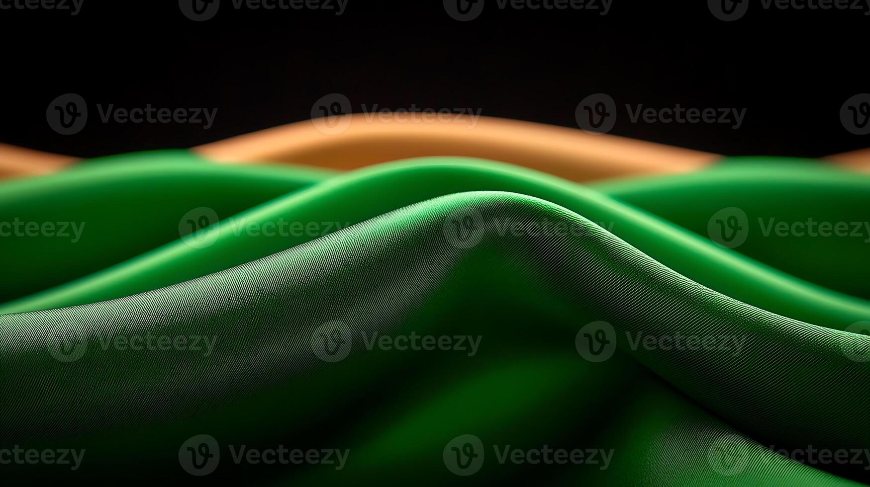 Close-up view of flowing fabric waves in vibrant green and orange colors against a dark background photo