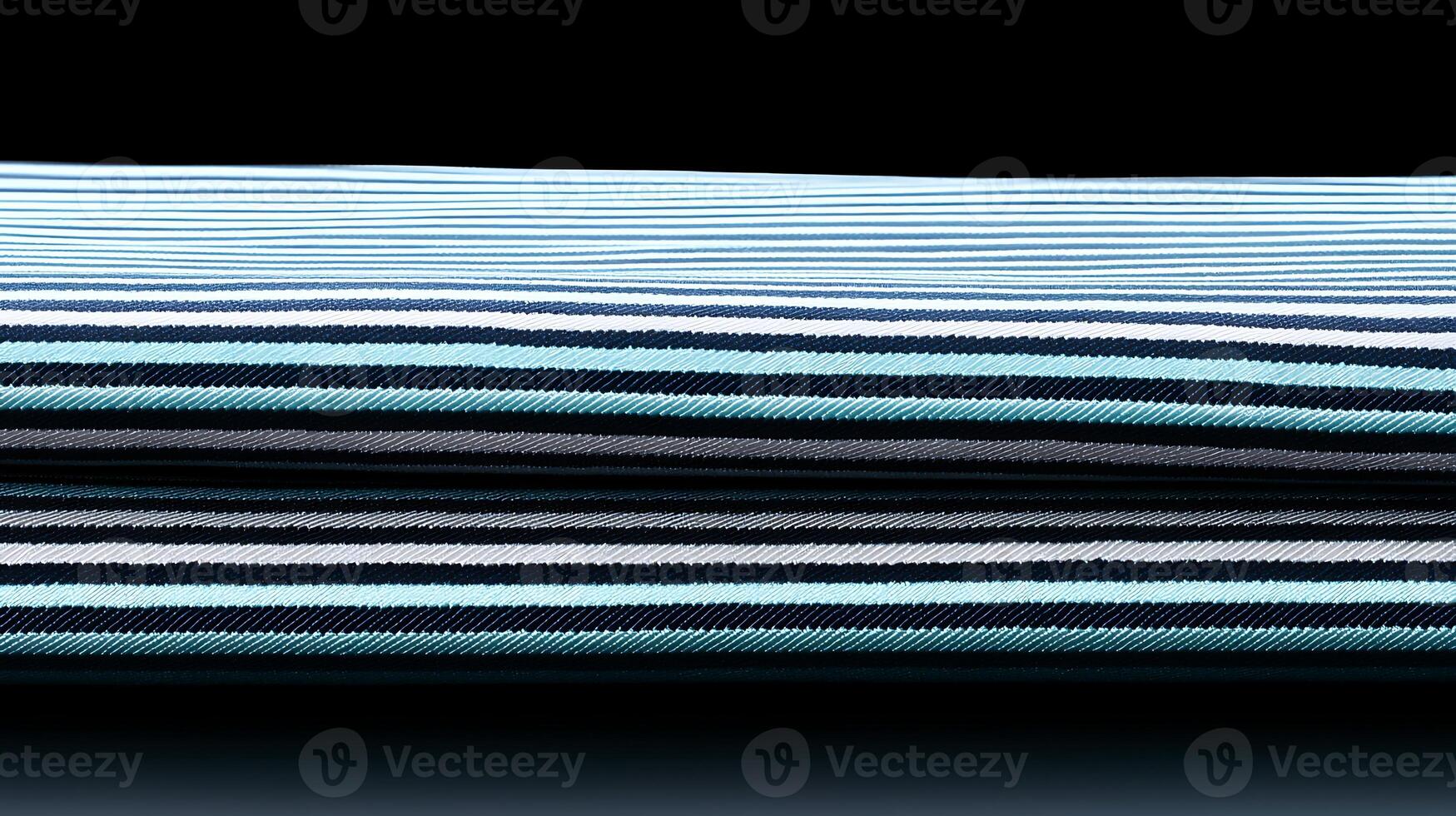 Close-up view of neatly stacked striped fabric showcasing a gradient of blue and black tones photo
