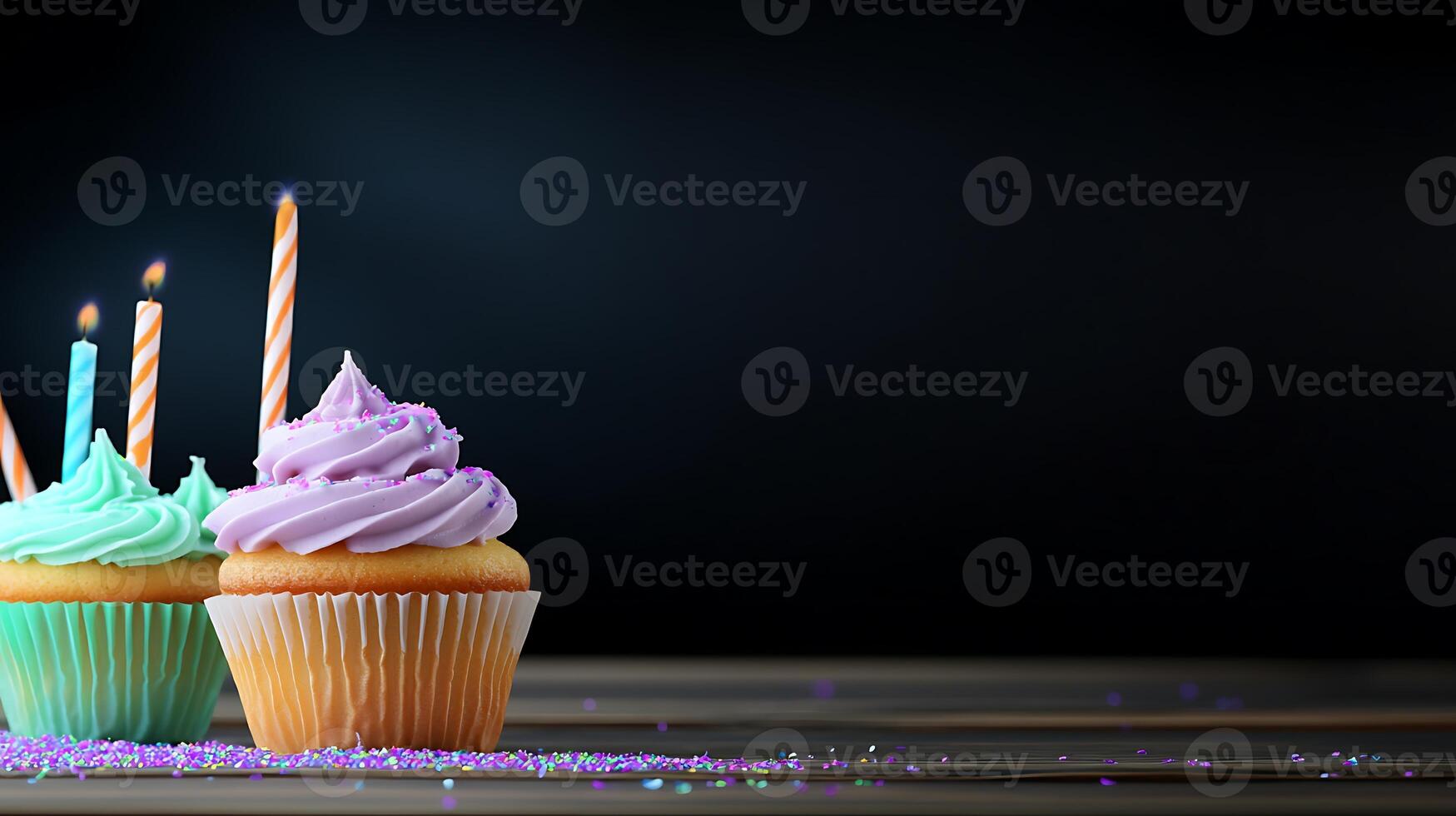 Colorful cupcakes with candles on a wooden table, set against a dark background for celebration photo