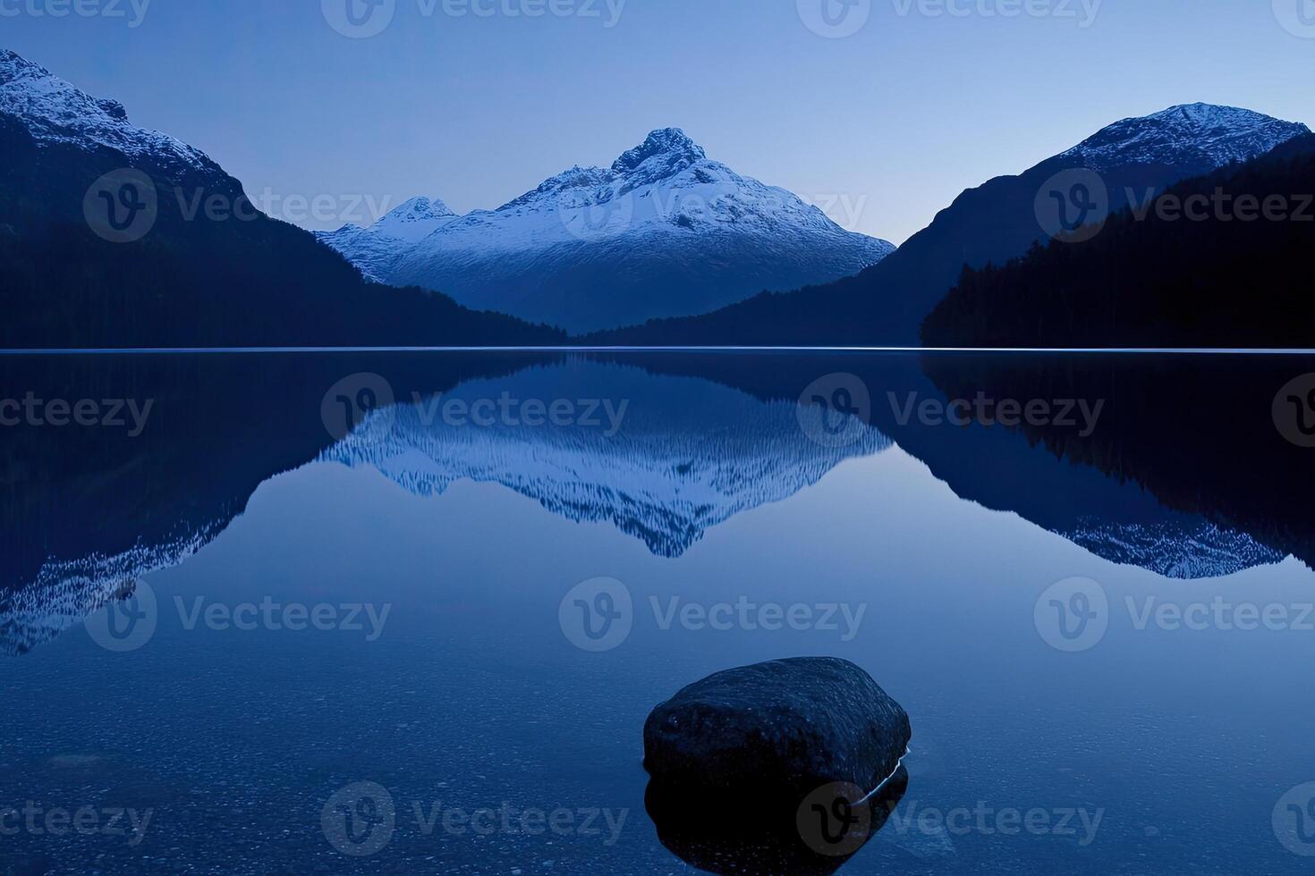 A mountain is reflected in a lake at dusk photo