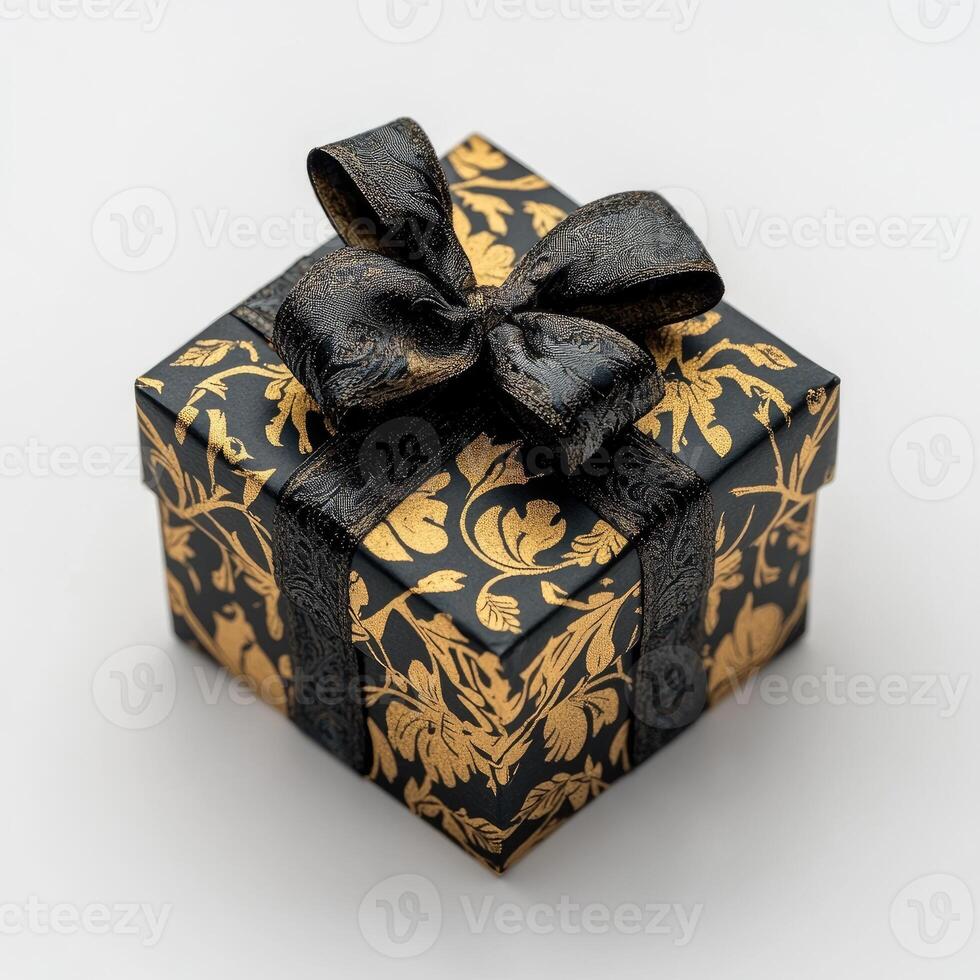 Elegant black gift box with gold patterned design and a black ribbon bow photo