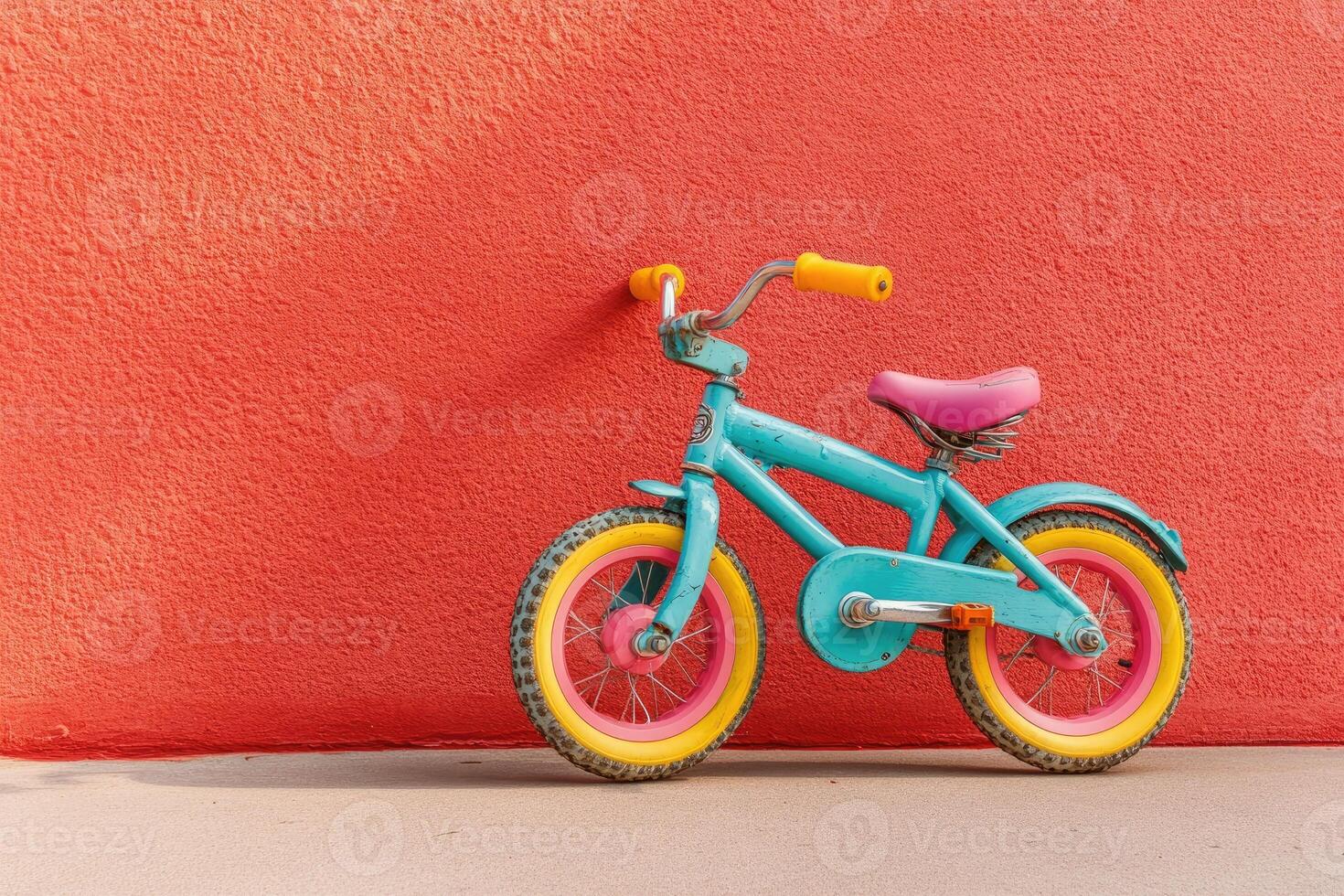 Teal bike leaning against vibrant coral wall photo