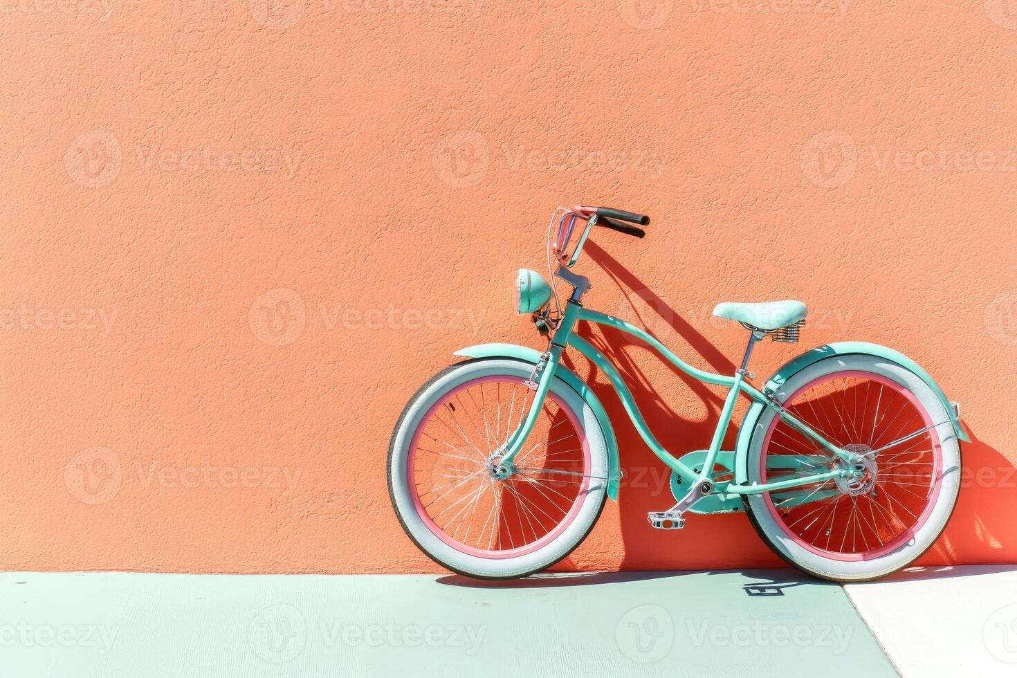 Mint green bicycle against coral wall photo