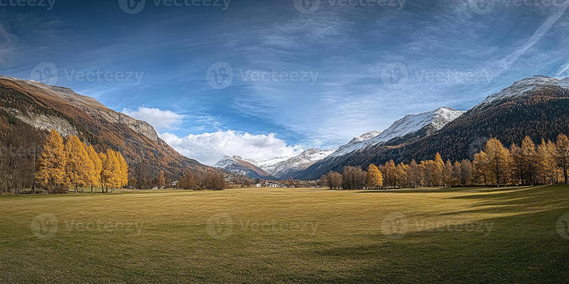 Autumnal alpine valley with golden trees and snowy peaks photo