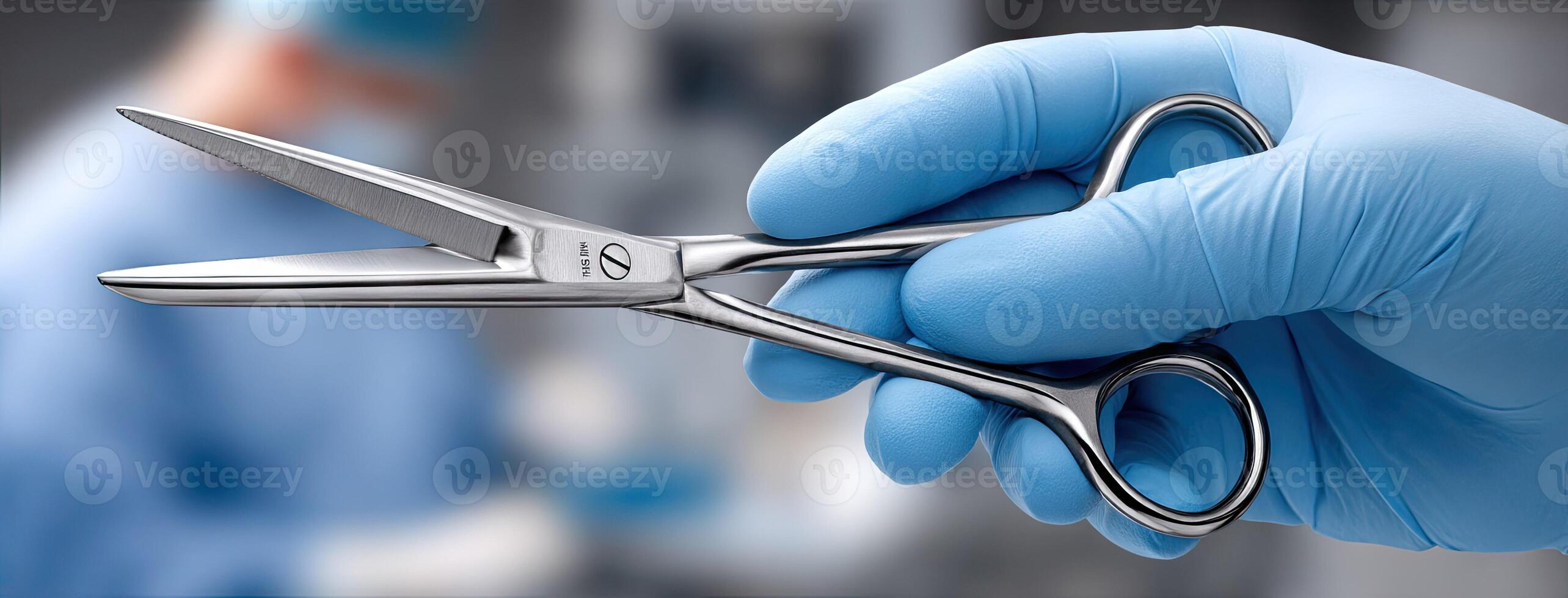 A person in blue gloves holding a pair of scissors photo