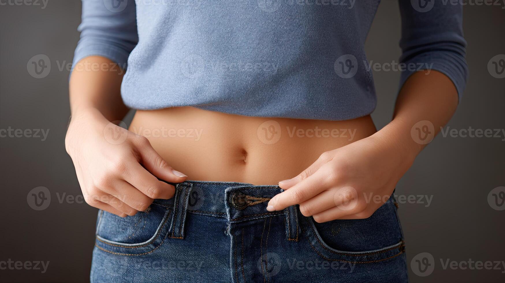 A woman is holding her belly in her jeans photo