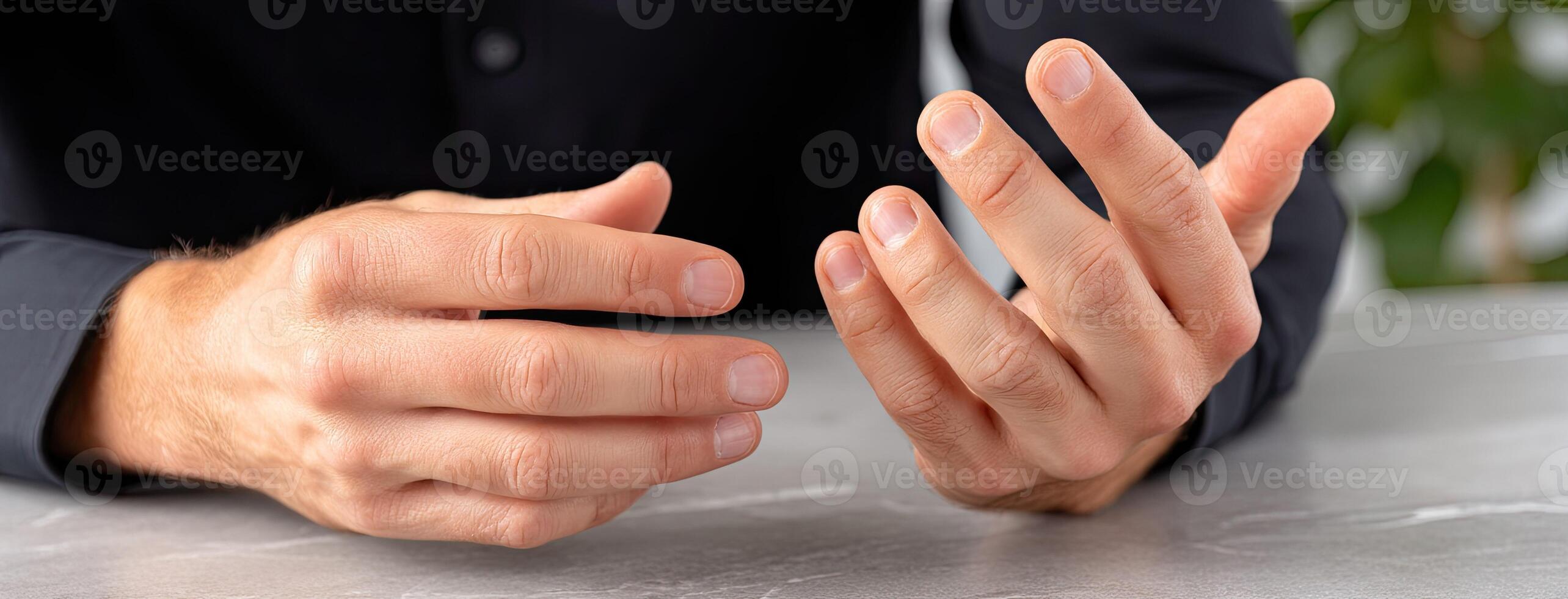 A man is holding his hands together on a table photo