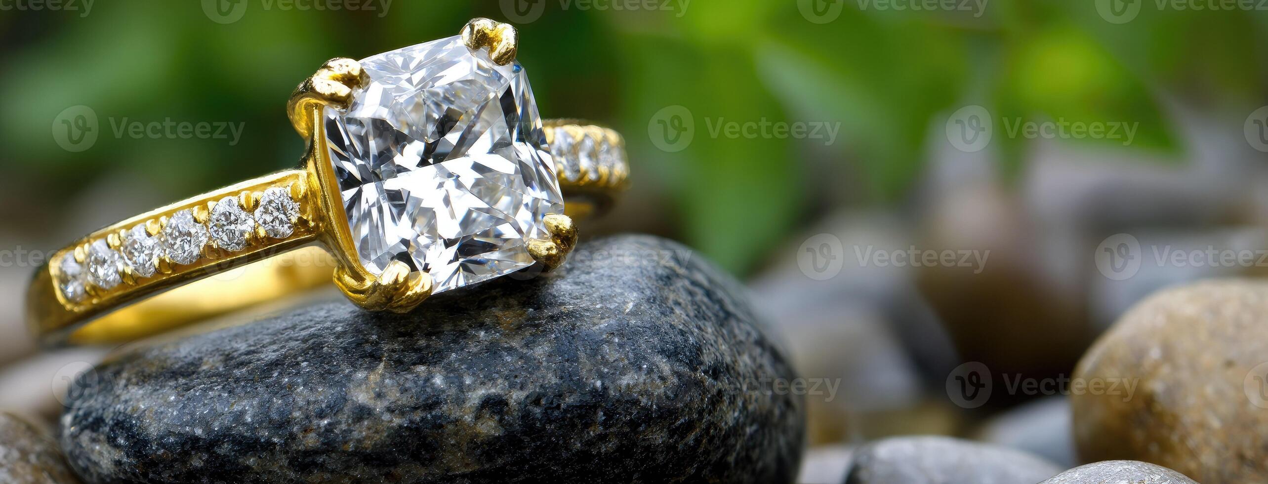 A diamond ring sits on top of a rock photo