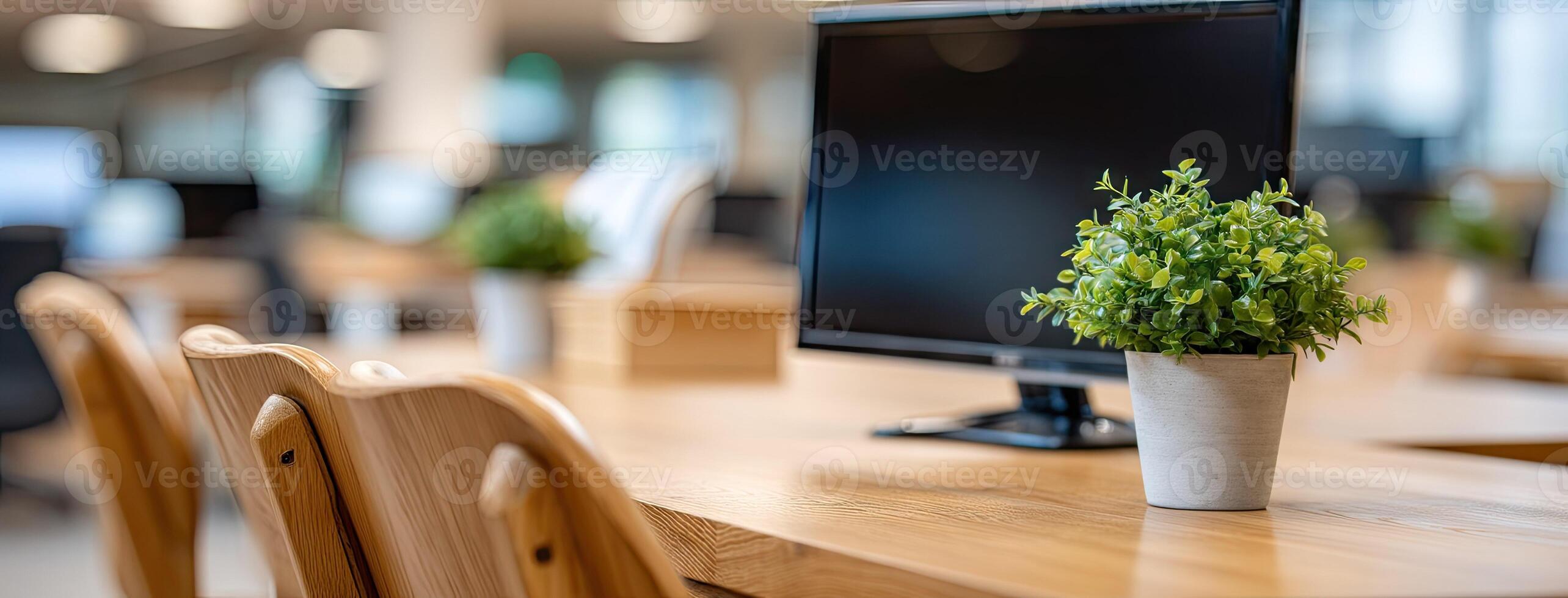 A computer monitor and a plant in a vase on a desk photo
