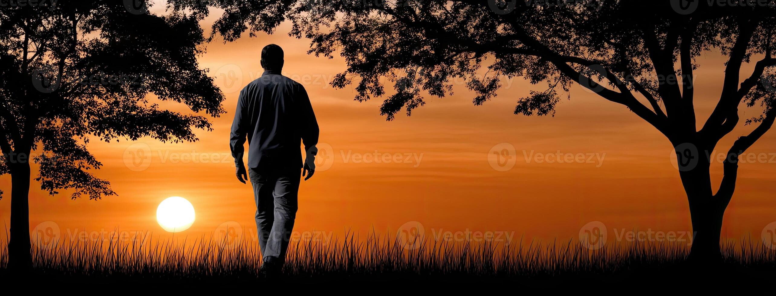 A man walking in the sunset with trees in the background photo