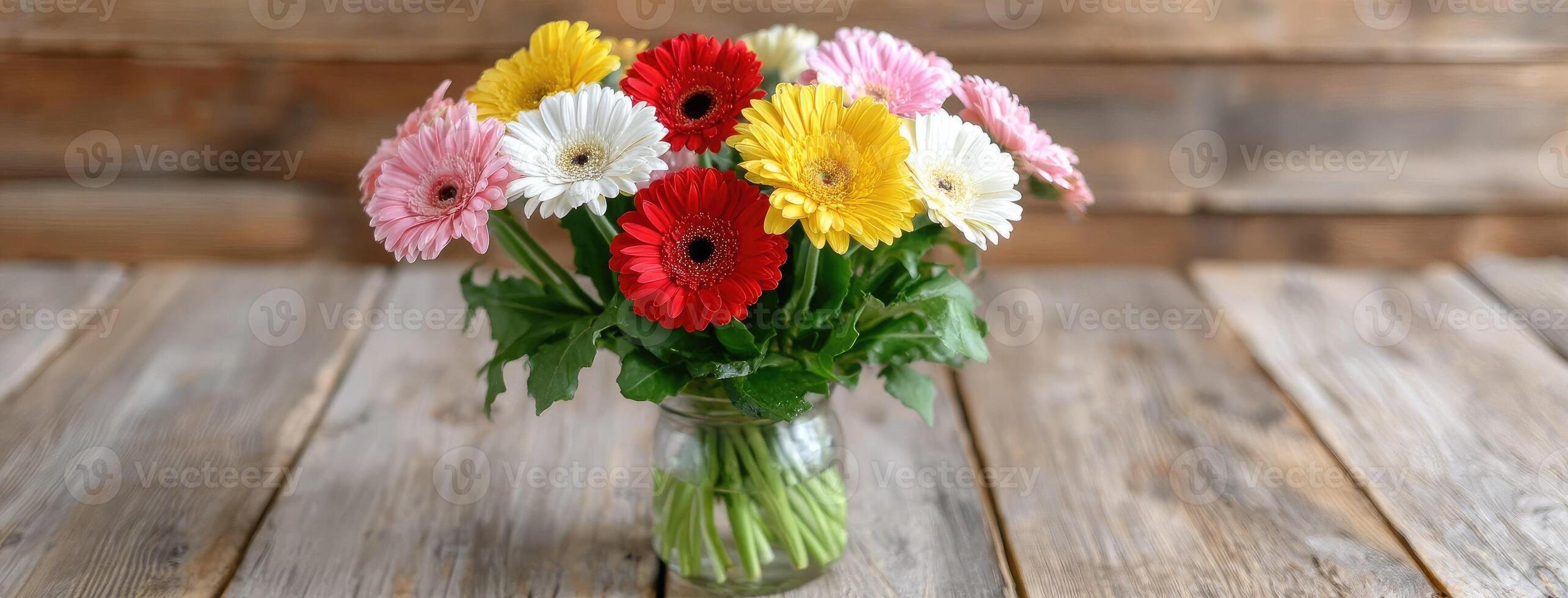 A vase filled with colorful gerberas on a wooden table photo
