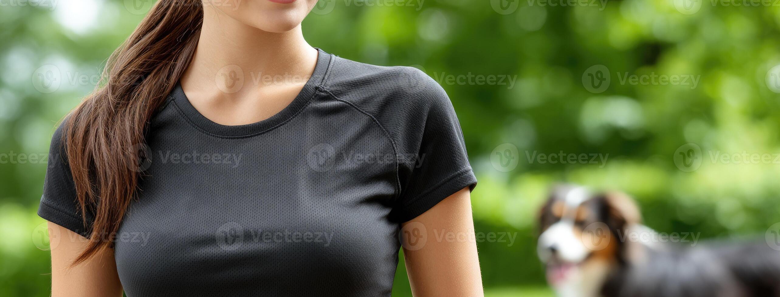 A woman in a black shirt is standing in front of a dog photo