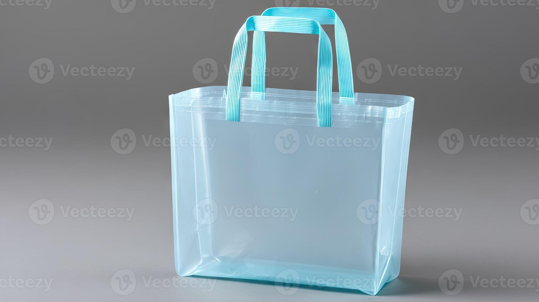 A clear plastic shopping bag with blue handles photo