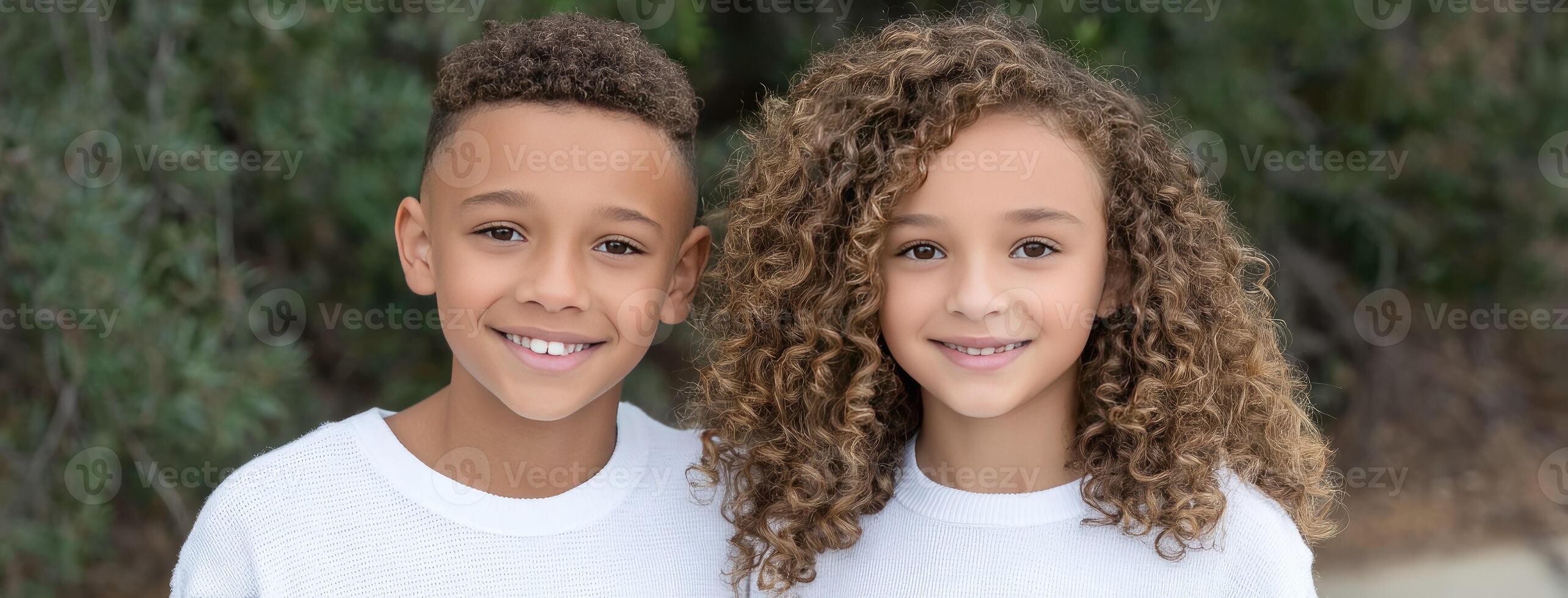 Two young children with curly hair posing for a photo