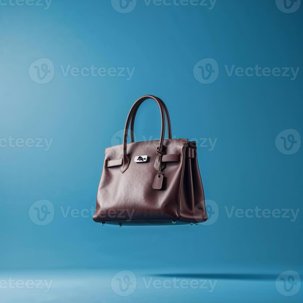 Luxurious brown leather handbag floating against a blue background showcasing elegance and style photo