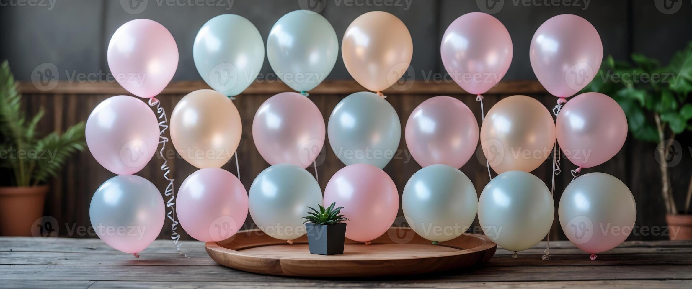 Colorful balloons arranged in soft hues at a celebration setting with indoor plants and wooden decor photo