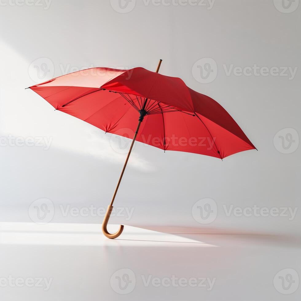 Bright red umbrella stands gracefully against a minimalist background in soft light photo