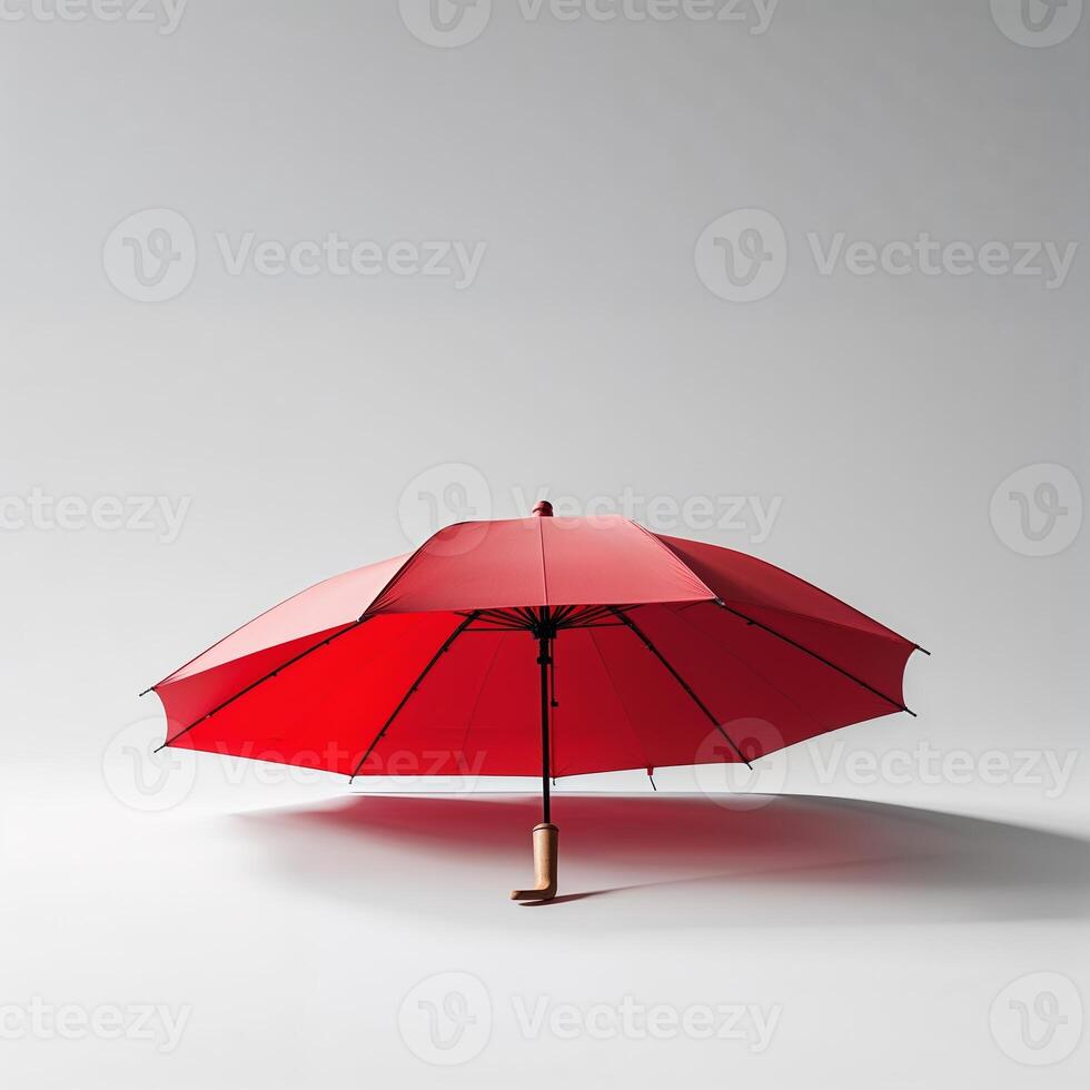 Bright red umbrella stands alone against a neutral background, showcasing its vibrant color and unique design in indoor light photo