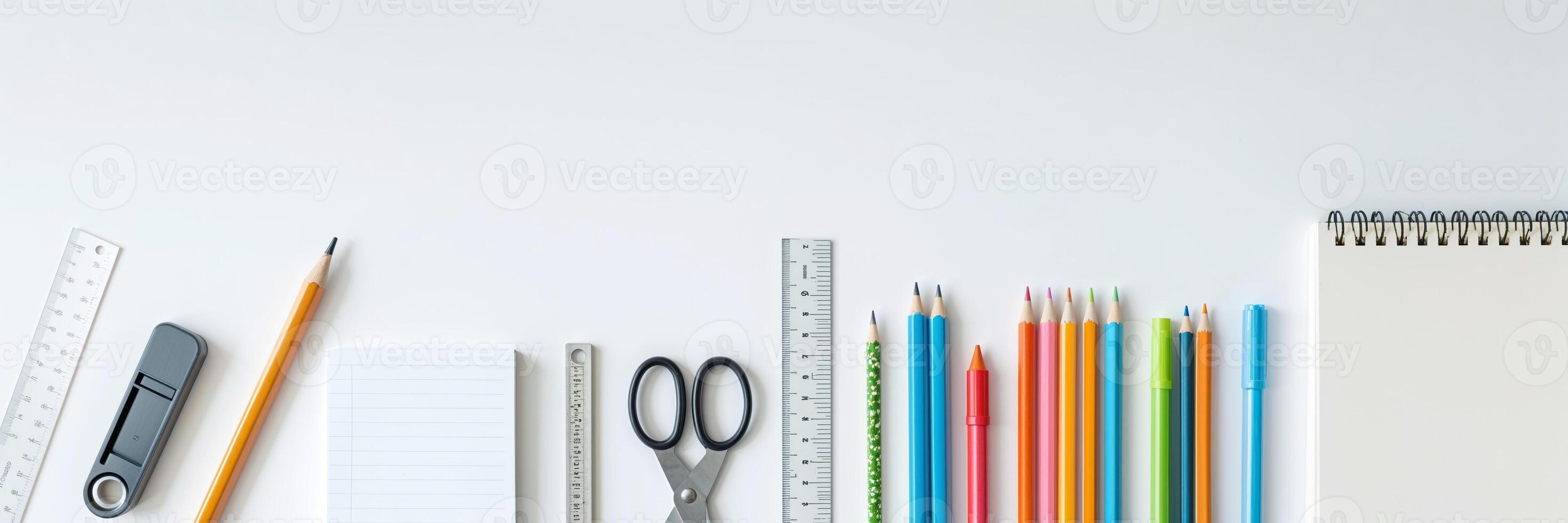 Colorful assortment of stationery items arranged neatly on a white surface for school or office use photo