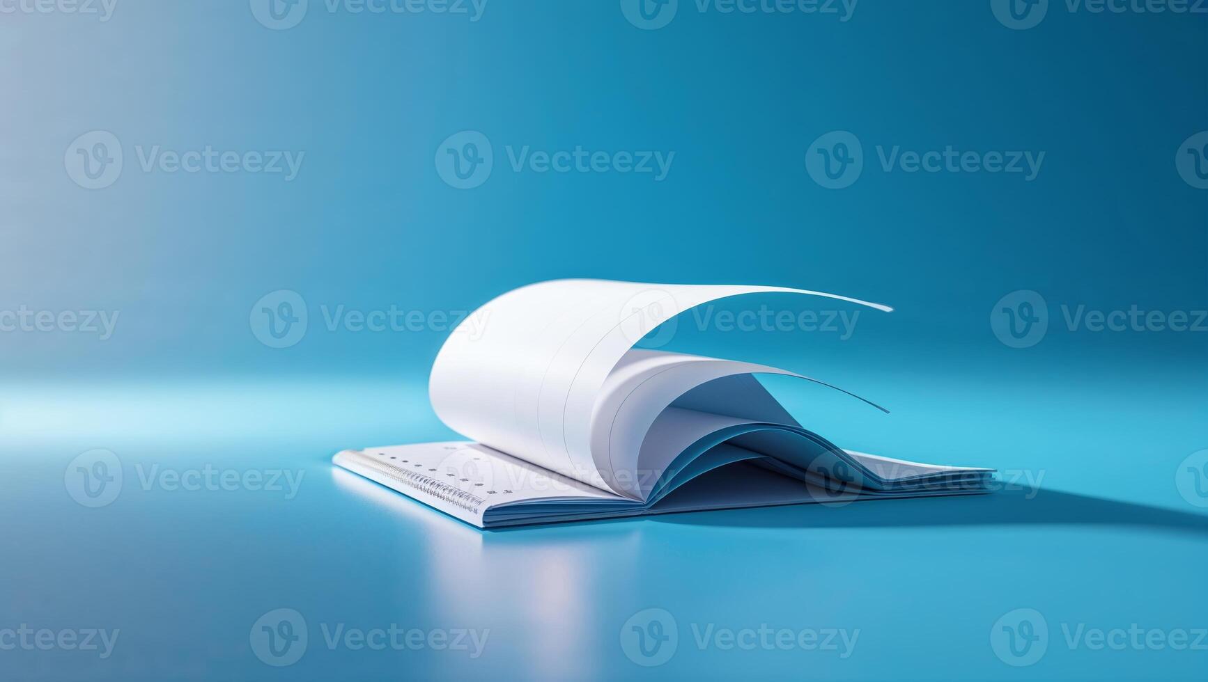 Open blank book with pages curling on a blue background showcasing creativity and imagination photo