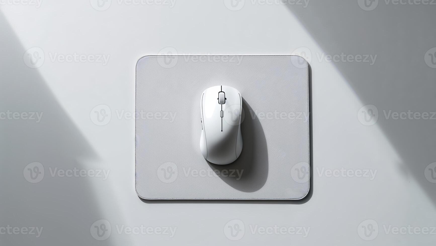 White computer mouse positioned on a light gray mousepad with soft shadows in the background photo