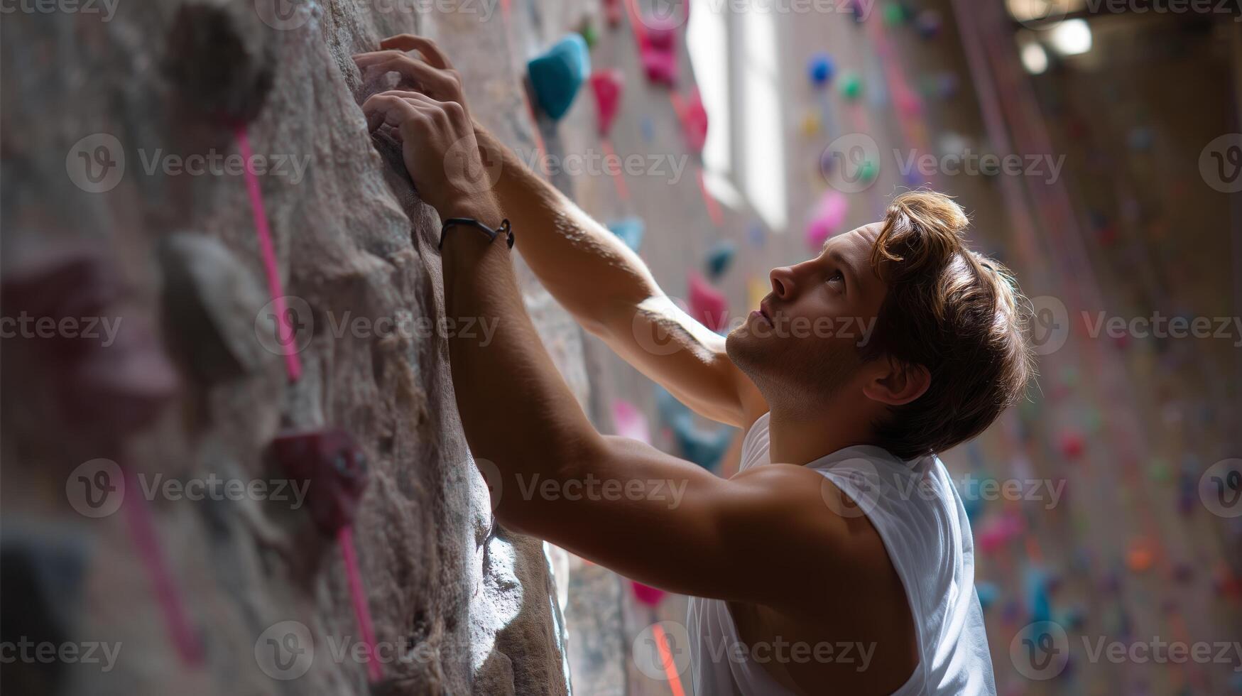 Climber tackling a vertical wall in an indoor rock climbing gym during the evening hours photo