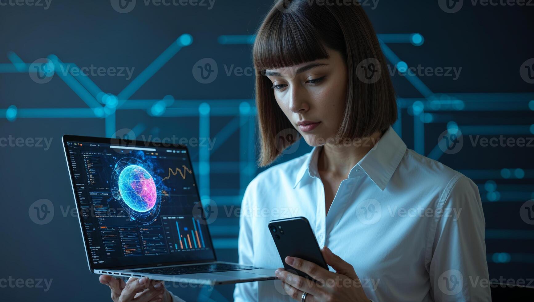 Business professional analyzes data on a laptop while using a smartphone in a modern office environment during the evening photo