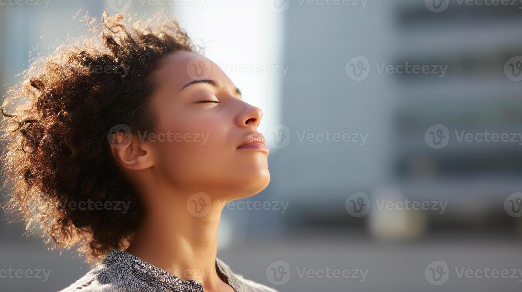 Woman enjoying tranquility outdoors in a city setting with a serene expression during daytime photo
