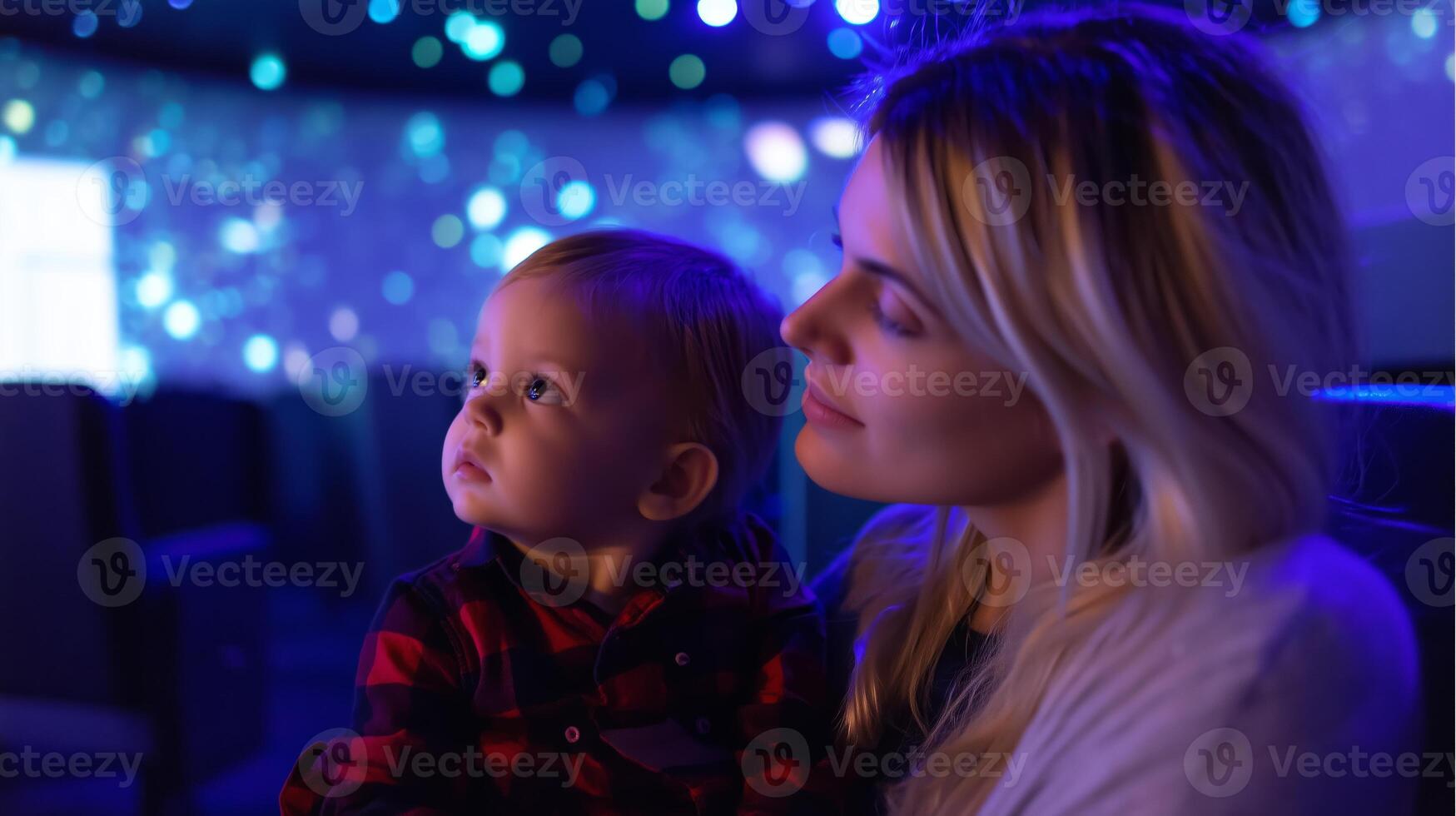 Mother and child captivated by colorful light display during evening event at local science center photo