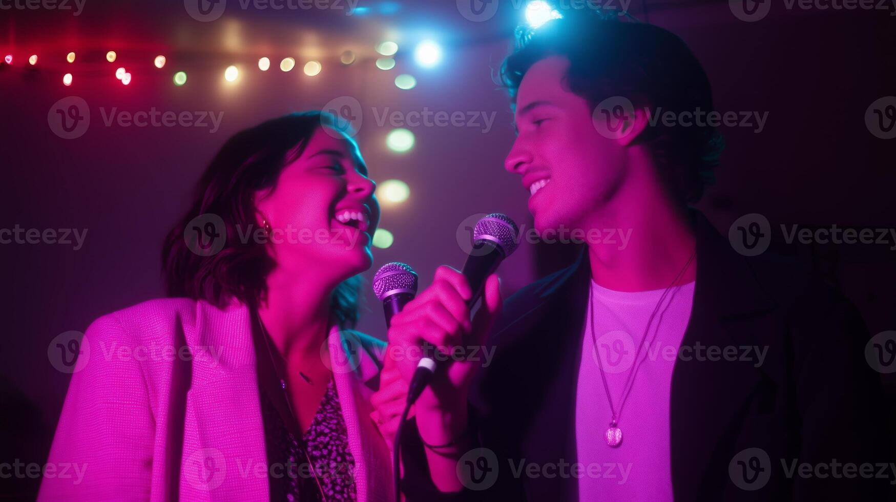 Young couple enjoys singing together at a colorful indoor party with vibrant lights during a fun night out photo
