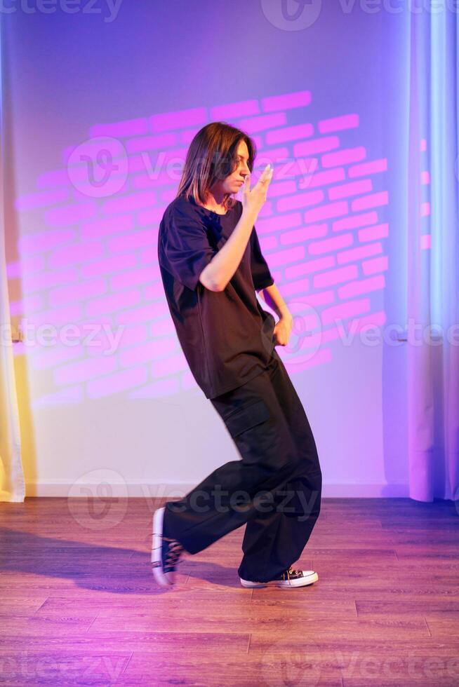 Energetic dance performance in modern studio with colorful lighting at night photo