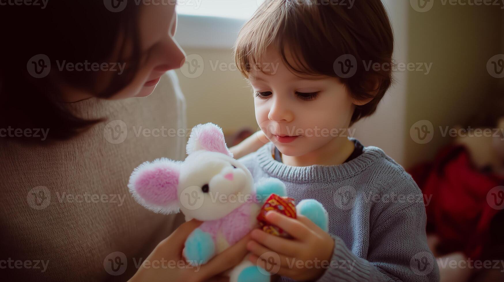 Child enjoys playtime with mother in cozy indoor setting while holding a stuffed animal and colorful toy photo