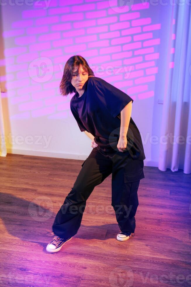 Dancer performing contemporary style in stylish urban setting with colorful lighting at night photo