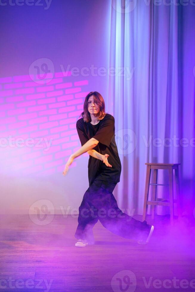 Dance performance featuring a solo dancer in a purple-lit atmosphere with fog and dramatic lighting photo