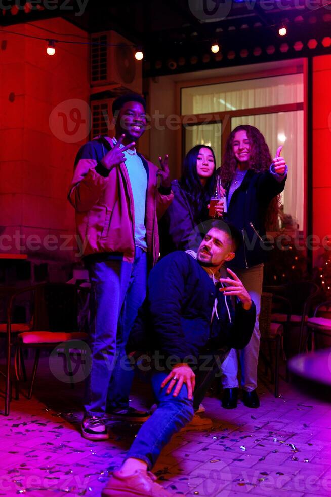 Group of friends celebrating with drinks and sparklers at a lively outdoor gathering in the evening photo