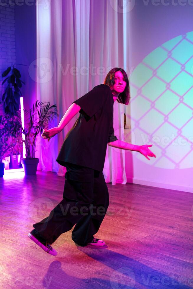 Dancer showcasing contemporary moves in colorful studio setting during evening performance photo