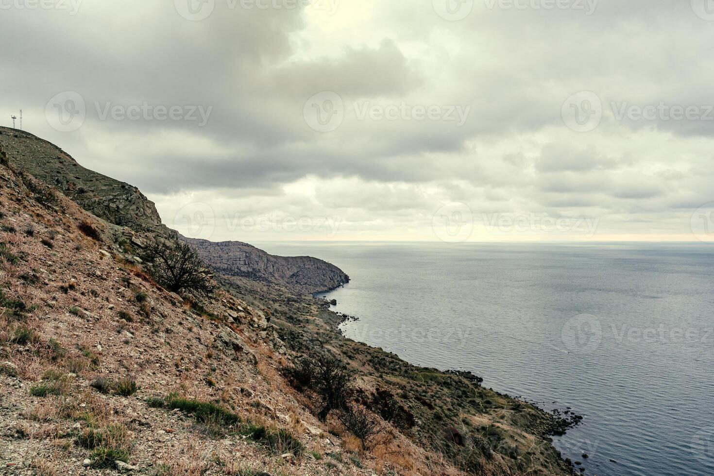 Scenic coastline view with rocky cliffs and cloudy skies at a coastal location photo