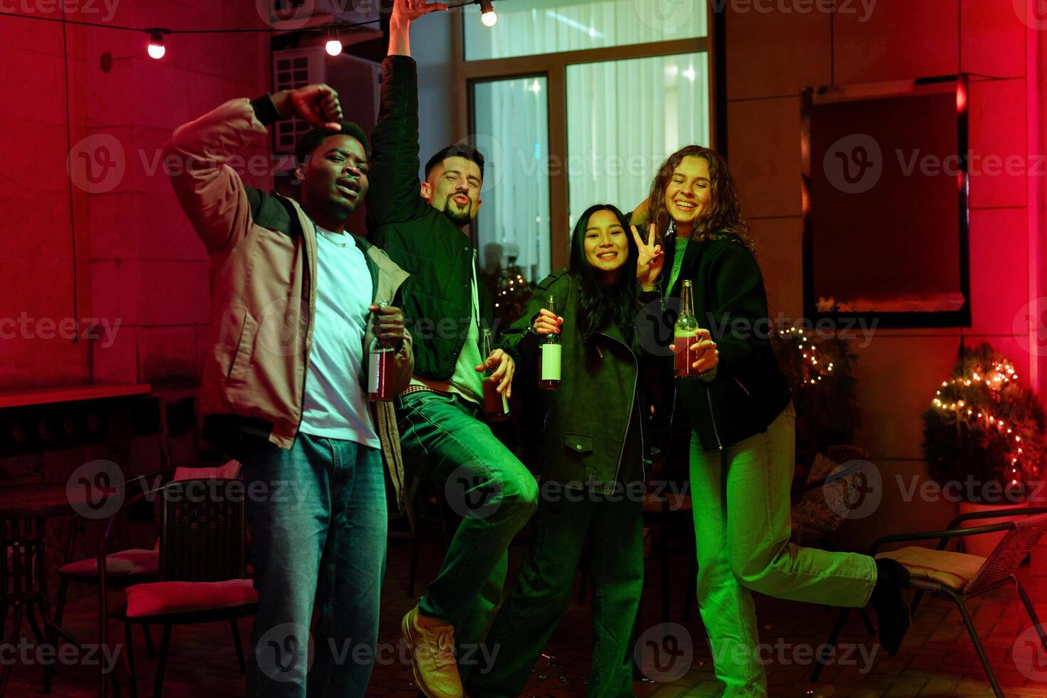 Friends celebrate at an evening gathering with drinks and laughter in a cozy outdoor setting photo