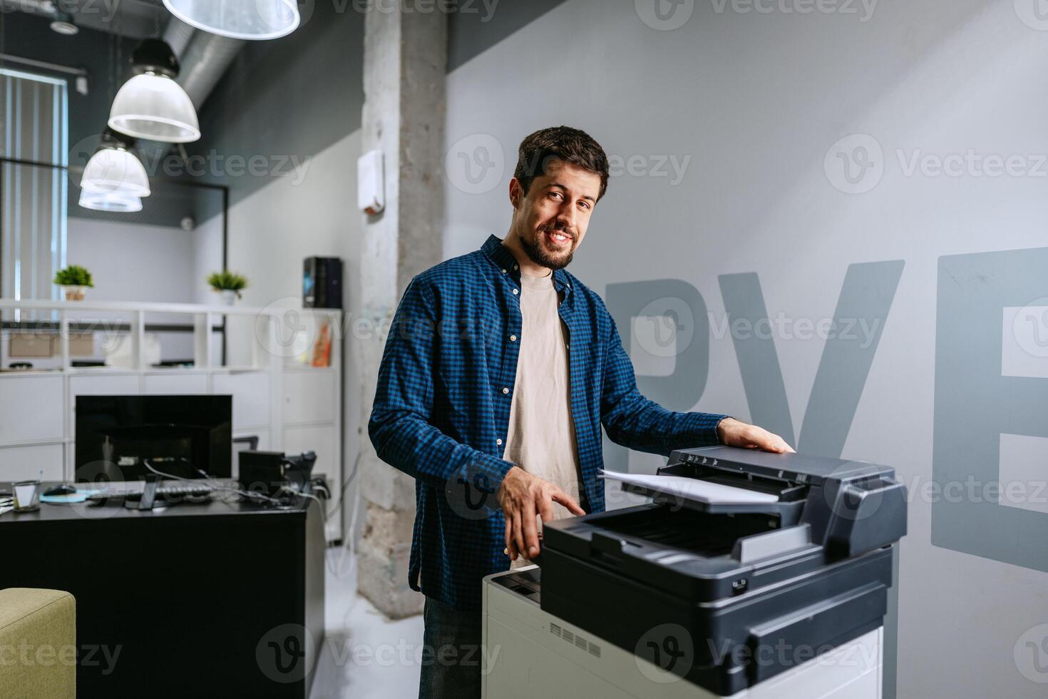 Printing documents in a modern office while smiling in a casual outfit photo