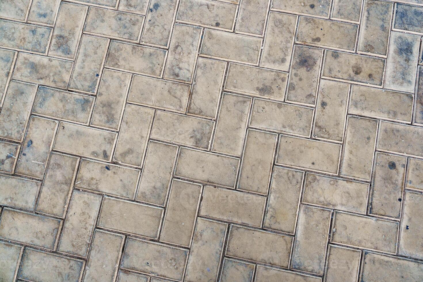 Detailed view of textured paving stones in a city setting highlighting their unique patterns and wear marks photo